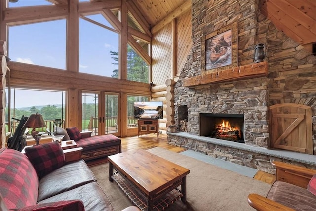 living room featuring a fireplace, hardwood / wood-style floors, high vaulted ceiling, and french doors