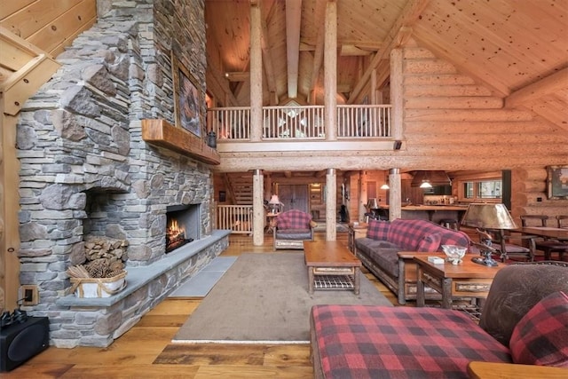 unfurnished living room with wood ceiling, log walls, light hardwood / wood-style flooring, high vaulted ceiling, and a stone fireplace