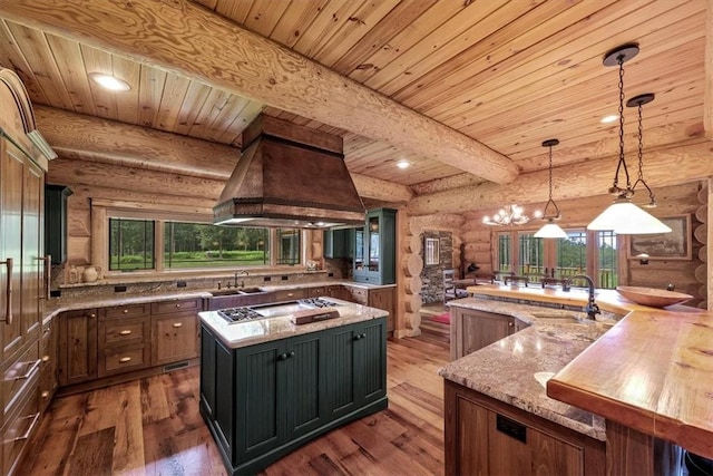 kitchen featuring a large island, log walls, pendant lighting, and hardwood / wood-style flooring