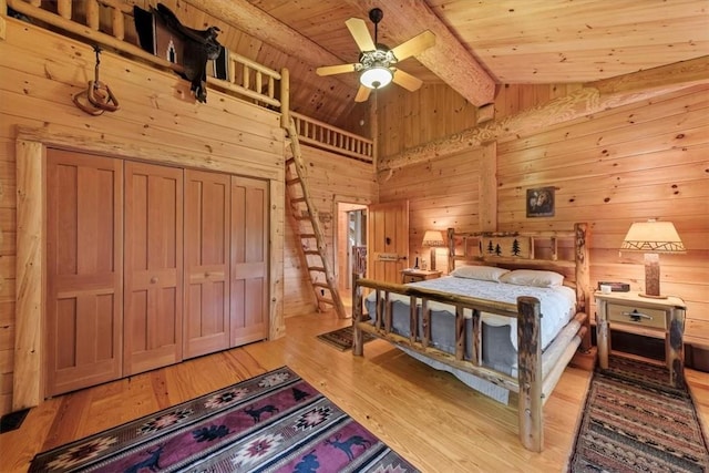 bedroom featuring light wood-type flooring, lofted ceiling with beams, ceiling fan, and wood ceiling