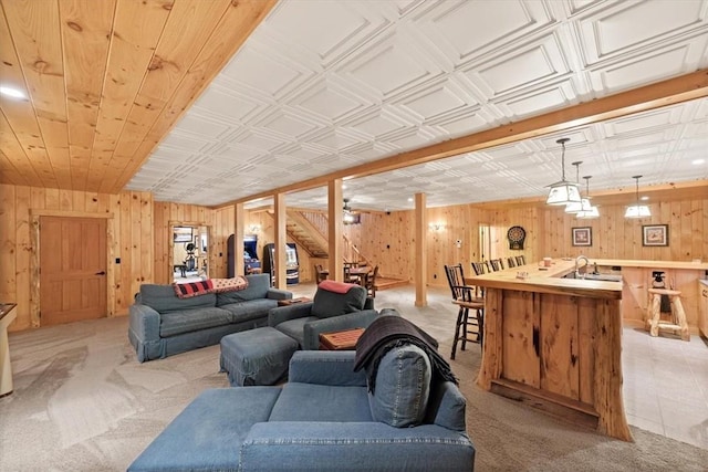 carpeted living room featuring wood walls and sink