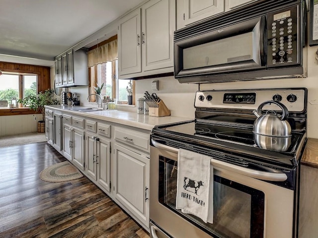 kitchen featuring electric stove, sink, and dark wood-type flooring