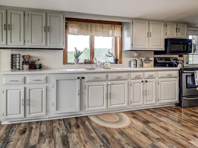 kitchen with white cabinetry, sink, stainless steel range with electric cooktop, and dark hardwood / wood-style floors