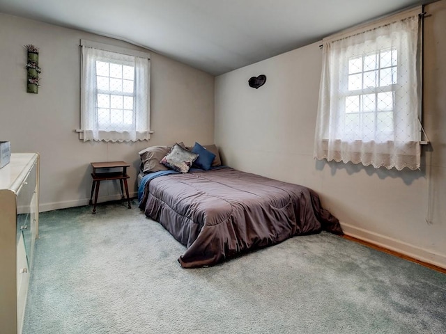 carpeted bedroom with lofted ceiling and multiple windows