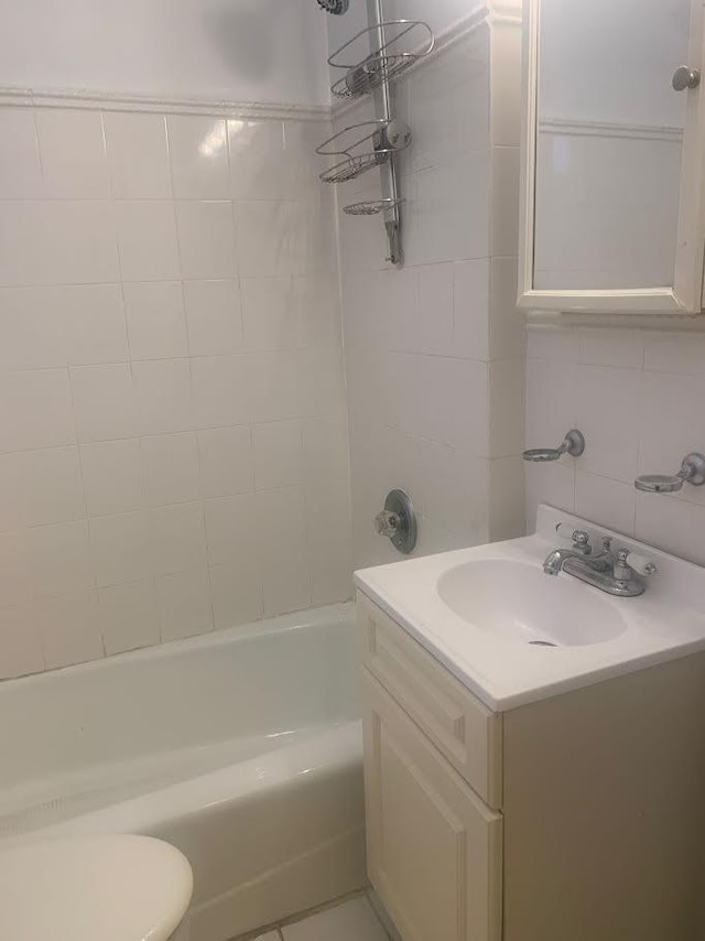 full bathroom with tasteful backsplash, vanity, tile walls, toilet, and tiled shower / bath