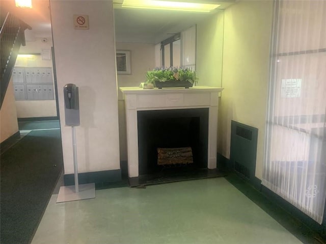 living room with a fireplace, radiator, and concrete floors