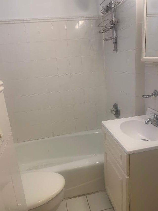 full bathroom with tile patterned flooring, vanity, tiled shower / bath combo, and toilet