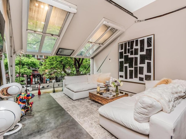 living room with a skylight, a wealth of natural light, and concrete floors