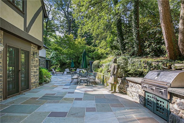 view of patio featuring exterior kitchen, outdoor dining space, and area for grilling