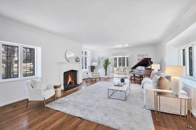 living area with a lit fireplace, plenty of natural light, wood finished floors, and crown molding