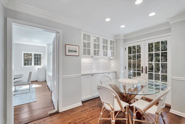 dining area featuring baseboards, ornamental molding, french doors, light wood-type flooring, and recessed lighting