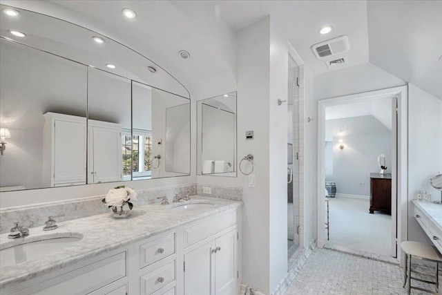 bathroom with a sink, visible vents, vaulted ceiling, double vanity, and a stall shower