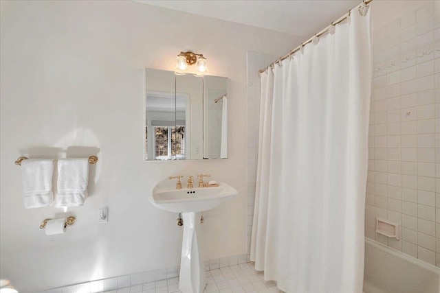 bathroom with tile patterned flooring, a sink, baseboards, and shower / bath combo with shower curtain