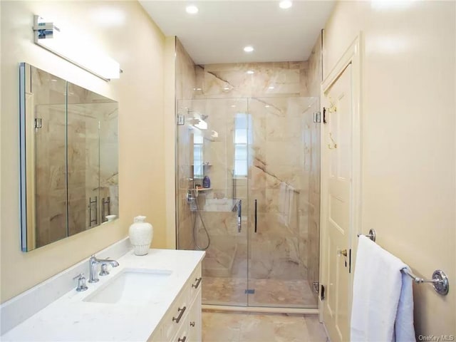 bathroom featuring vanity and a shower with door