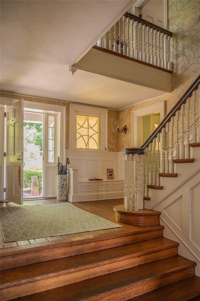 74 Tower Hill Loop, Tuxedo Park, NY 10987 - foyer with a decorative wall, wood finished floors, wallpapered walls, stairway, and a wainscoted wall