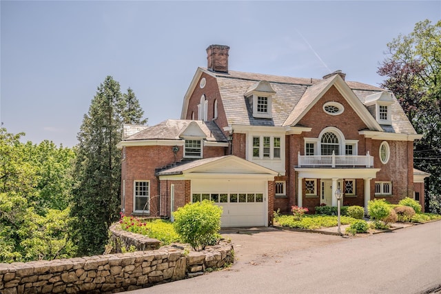 74 Tower Hill Loop, Tuxedo Park, NY 10987 - view of front of house featuring a balcony, a chimney, asphalt driveway, a garage, and brick siding