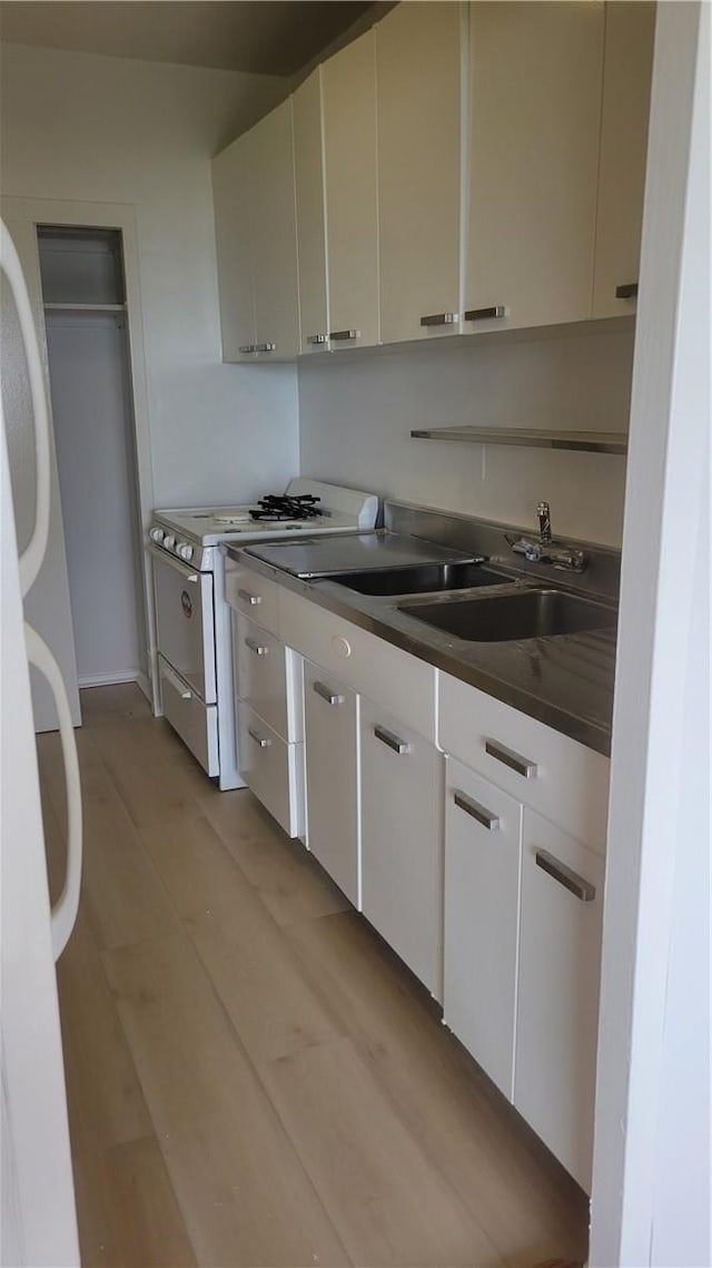 kitchen featuring white cabinetry, white appliances, and sink