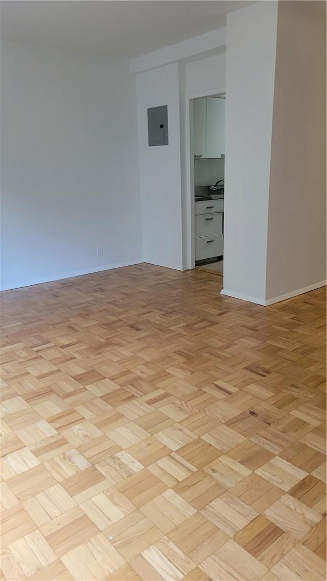 empty room featuring electric panel and light parquet floors