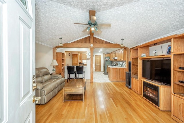 living room with light wood-type flooring, ornamental molding, a textured ceiling, vaulted ceiling, and ceiling fan