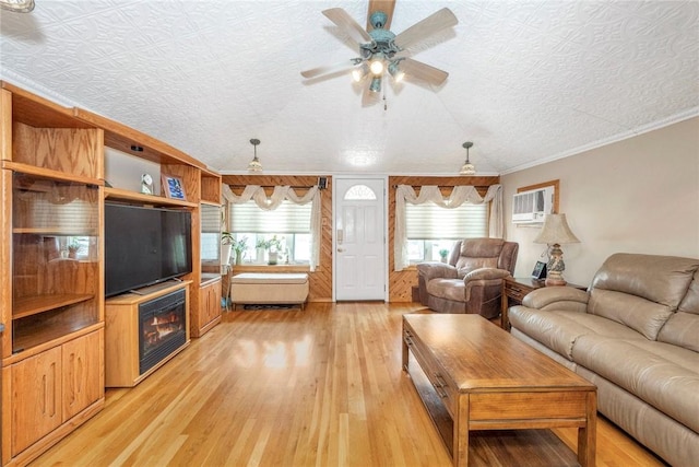 living room featuring a textured ceiling, light wood-type flooring, a wall mounted AC, and crown molding