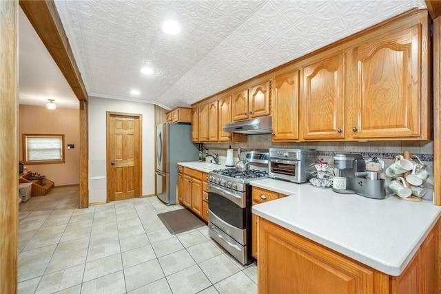 kitchen featuring stainless steel appliances, tasteful backsplash, a textured ceiling, light tile patterned flooring, and ornamental molding