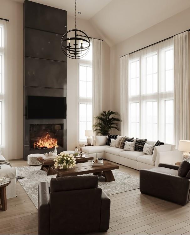 living room featuring a wealth of natural light, light hardwood / wood-style flooring, a chandelier, and vaulted ceiling