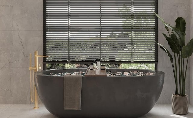 bathroom with a bathing tub, tile patterned flooring, and tile walls