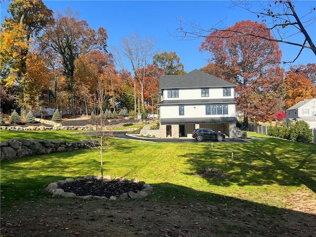 rear view of property featuring a lawn