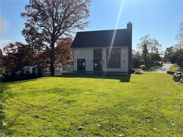 back of house featuring a lawn