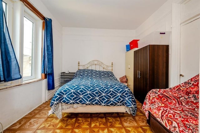 bedroom featuring parquet flooring and multiple windows