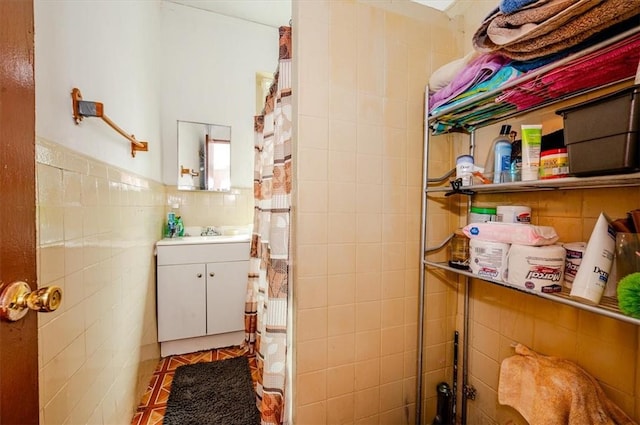 bathroom with tile patterned floors, sink, tile walls, and walk in shower