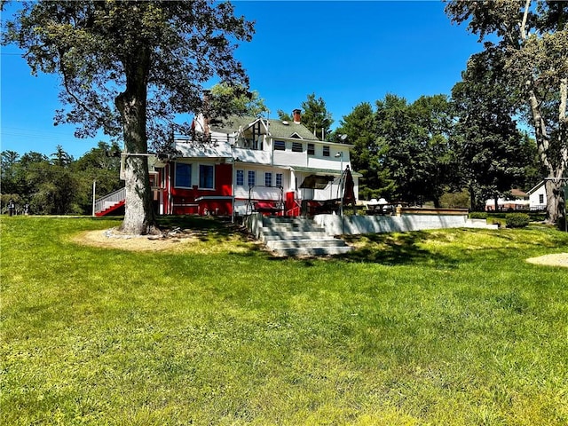 rear view of property with a yard