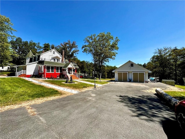 view of front of home featuring an outbuilding, a garage, and a front yard