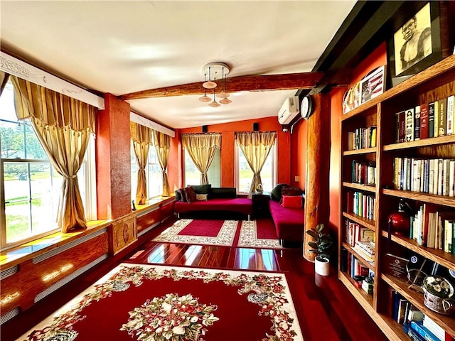 living area with dark hardwood / wood-style flooring, vaulted ceiling, plenty of natural light, and a wall unit AC