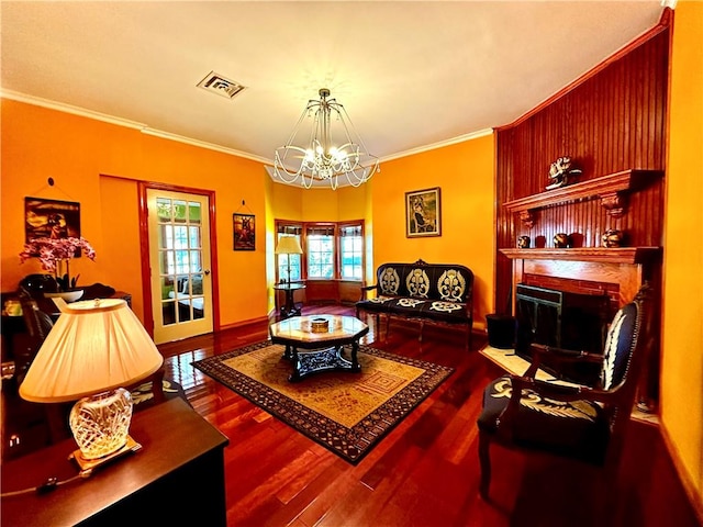 living room with crown molding, hardwood / wood-style floors, and a notable chandelier