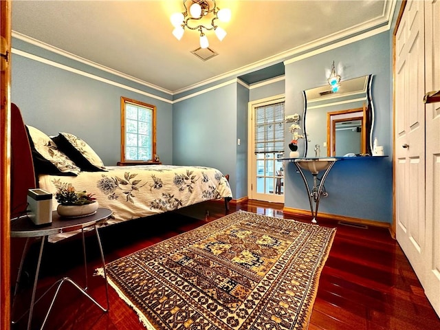 bedroom with crown molding, dark wood-type flooring, and an inviting chandelier