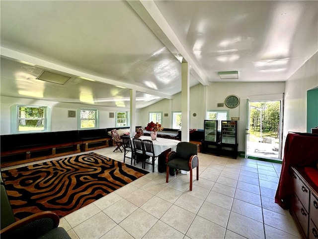 dining area featuring vaulted ceiling with beams and light tile patterned flooring