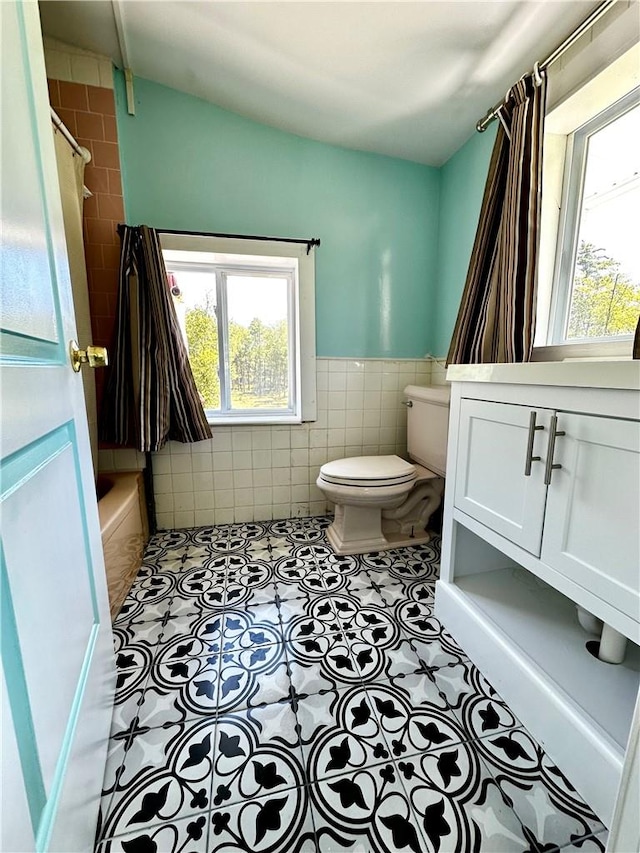 full bathroom with vanity,  shower combination, tile patterned flooring, toilet, and tile walls