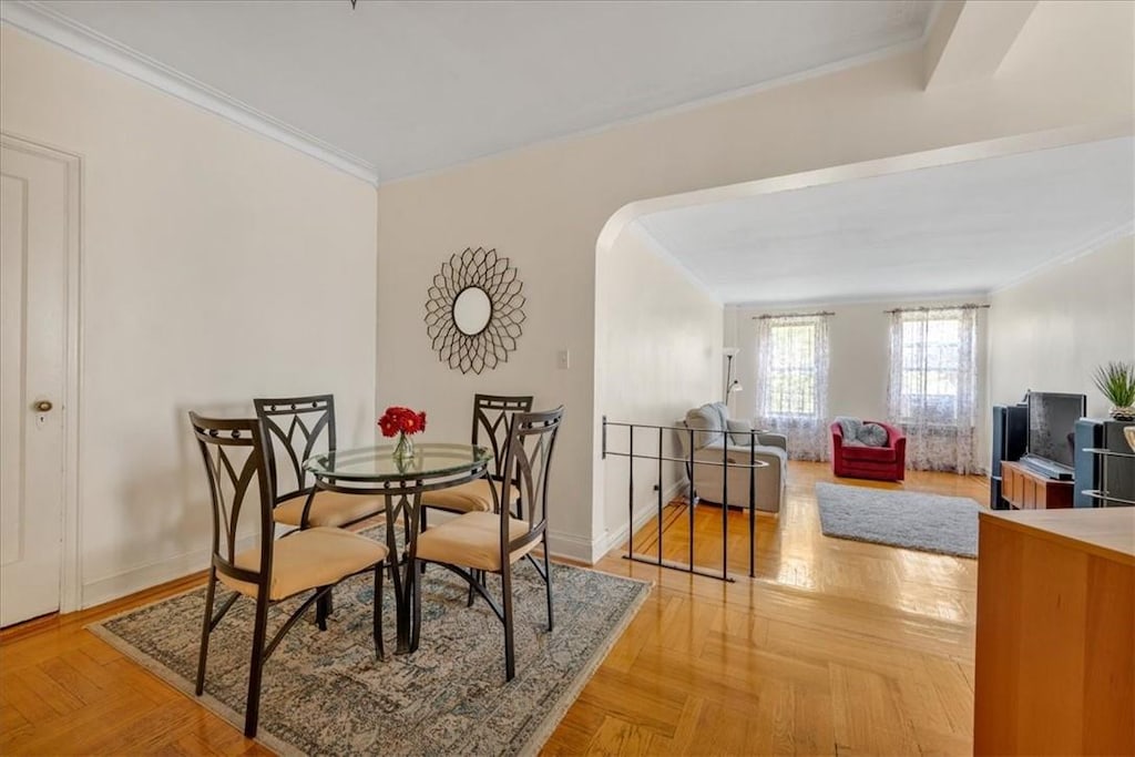 dining room featuring crown molding and light parquet flooring