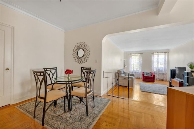 dining room featuring crown molding and light parquet flooring