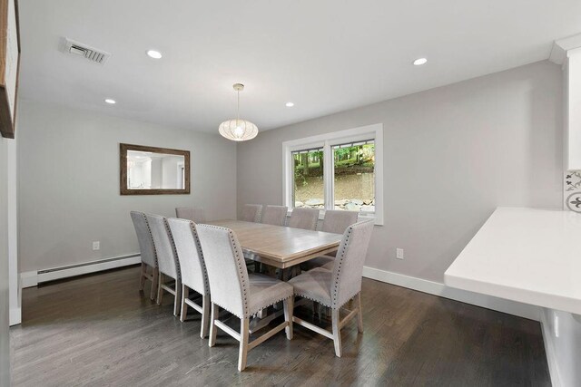 dining space with dark wood-type flooring, a baseboard radiator, and a notable chandelier