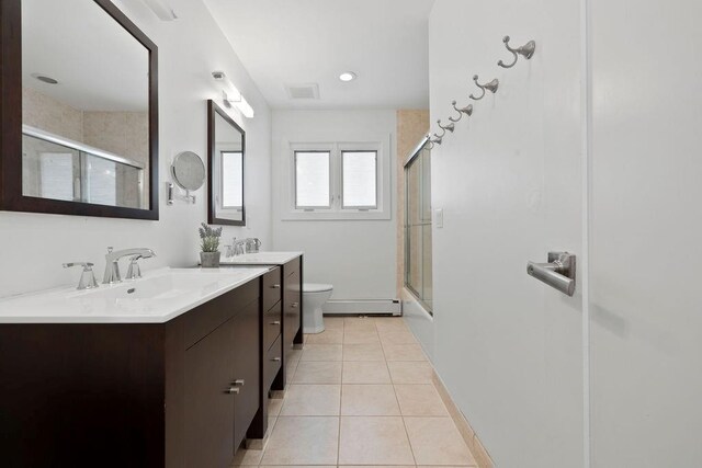 full bathroom with tile patterned floors, vanity, shower / bath combination with glass door, a baseboard radiator, and toilet