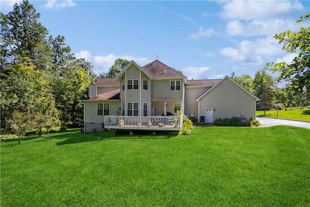 back of property with a yard and a deck