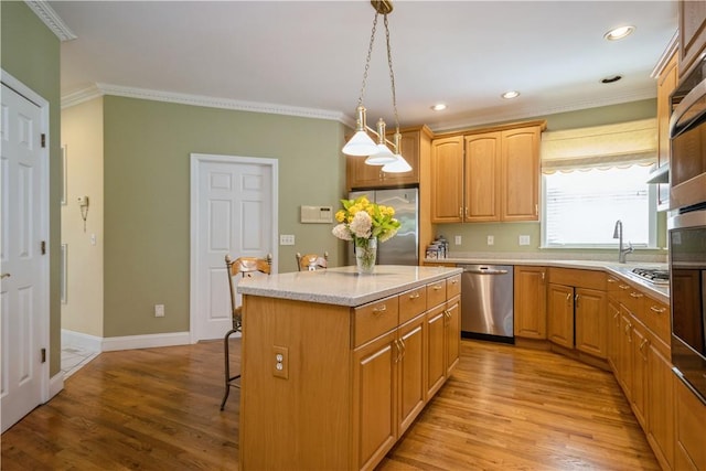 kitchen with light hardwood / wood-style flooring, a kitchen island, pendant lighting, and appliances with stainless steel finishes