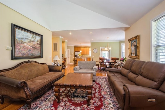 living room featuring crown molding, wood-type flooring, and vaulted ceiling