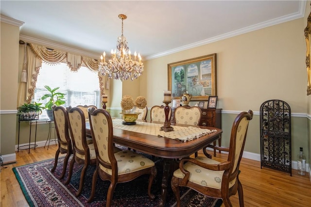 dining area featuring a chandelier, crown molding, and light hardwood / wood-style floors