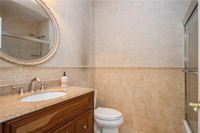 full bathroom featuring tasteful backsplash, bath / shower combo with glass door, toilet, vanity, and tile walls