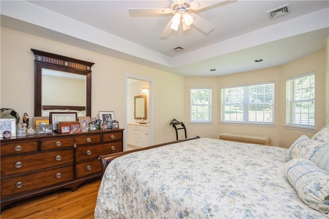 bedroom with light wood-type flooring, ensuite bath, and ceiling fan