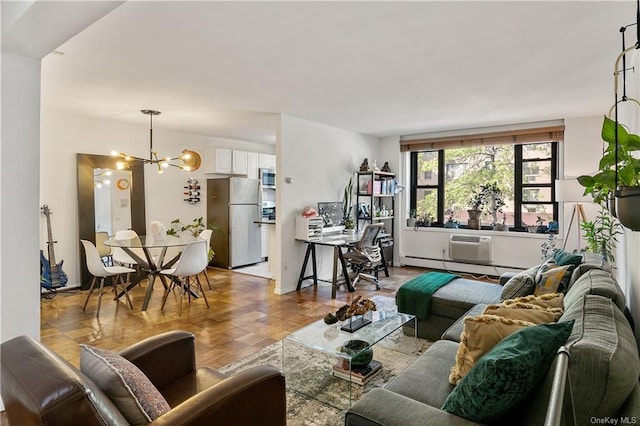 living room featuring a chandelier, light parquet flooring, and a baseboard heating unit