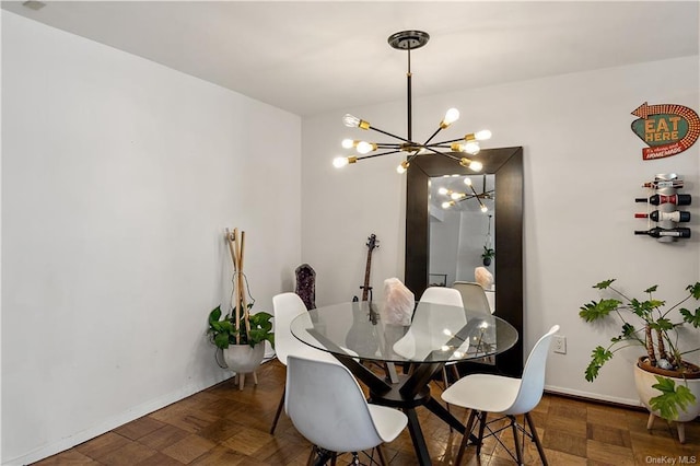 dining room featuring dark parquet flooring and an inviting chandelier